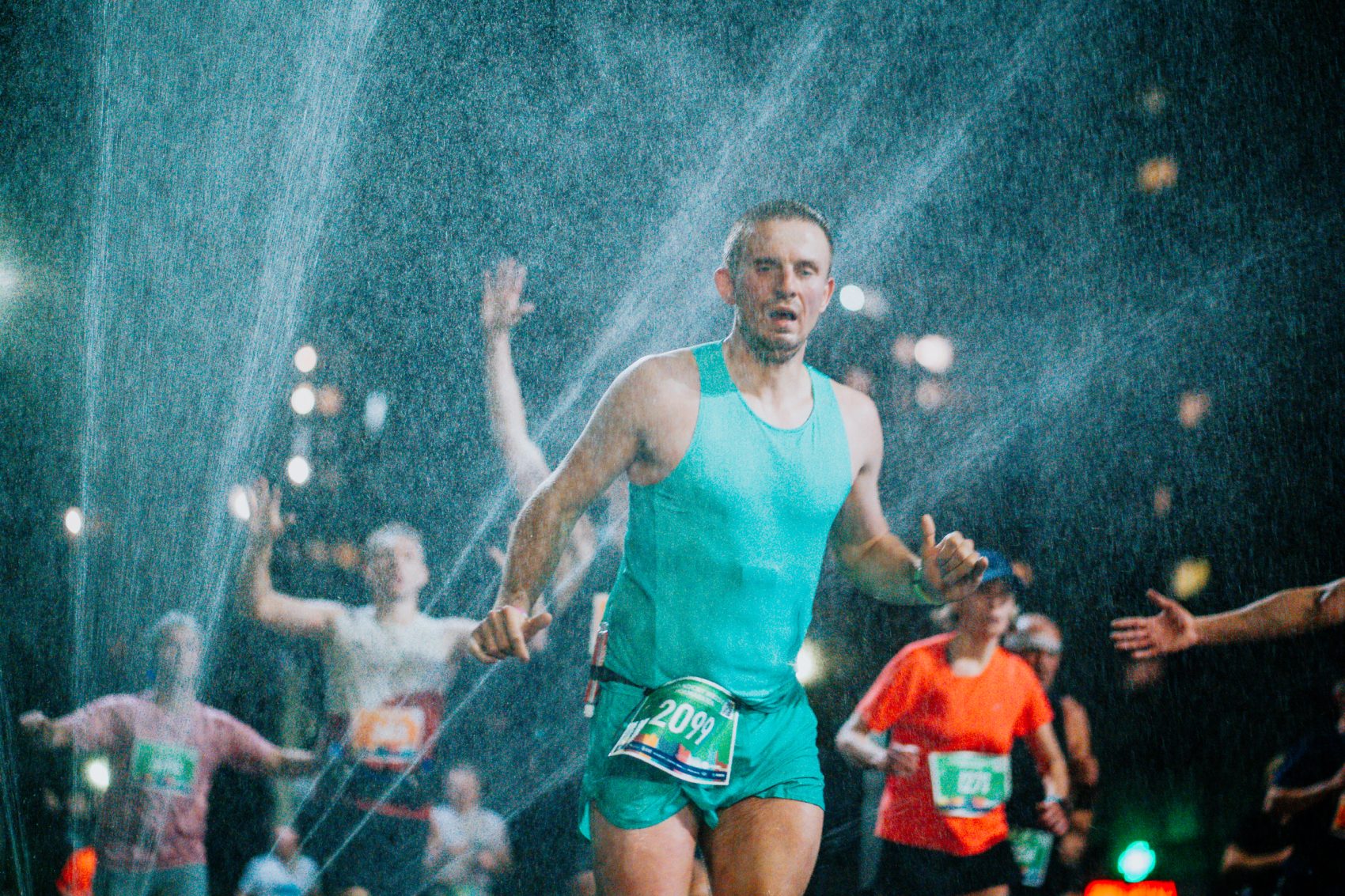 Na zdjęciu uczestnicy półmaratonu przebiegają przez kurtynę wodną MPWiK