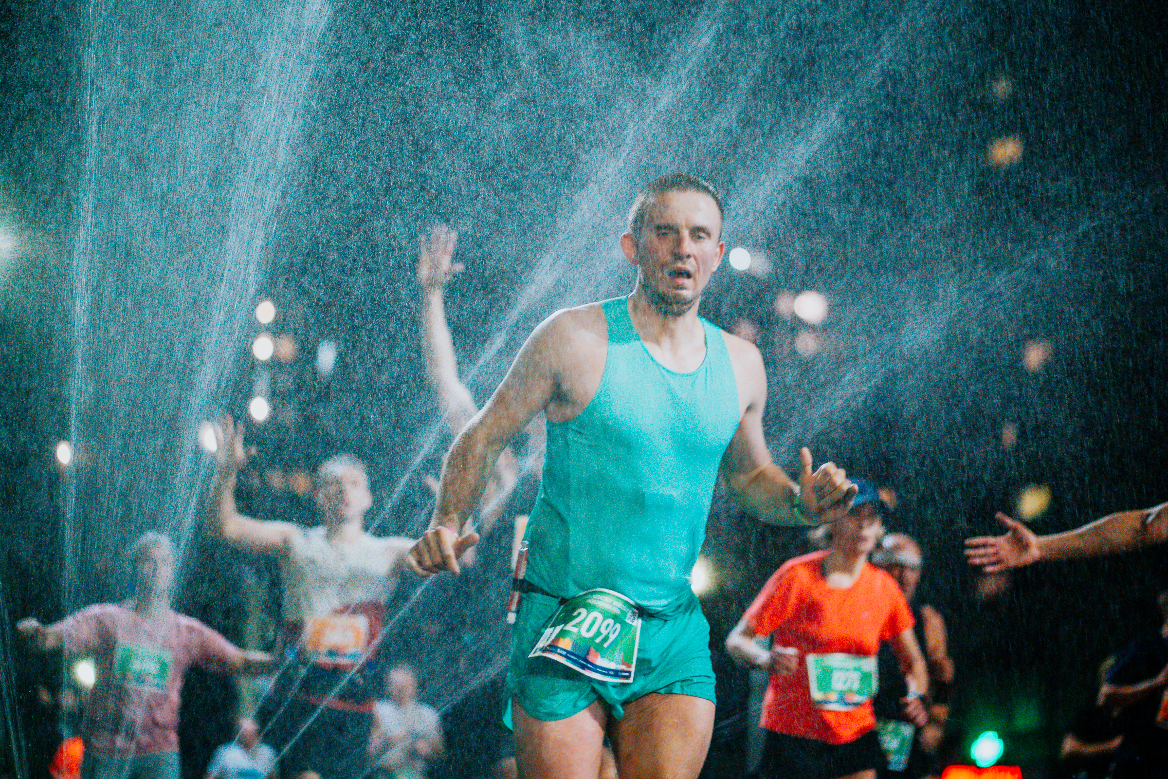Na zdjęciu uczestnicy półmaratonu przebiegają przez kurtynę wodną MPWiK