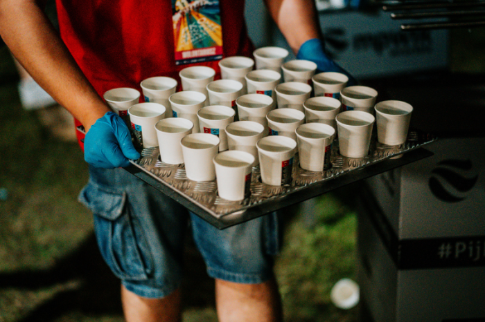 Wolontariusze pomagają rozdawać wodę uczestnikom biegu. Nocny Wrocław Połmaraton